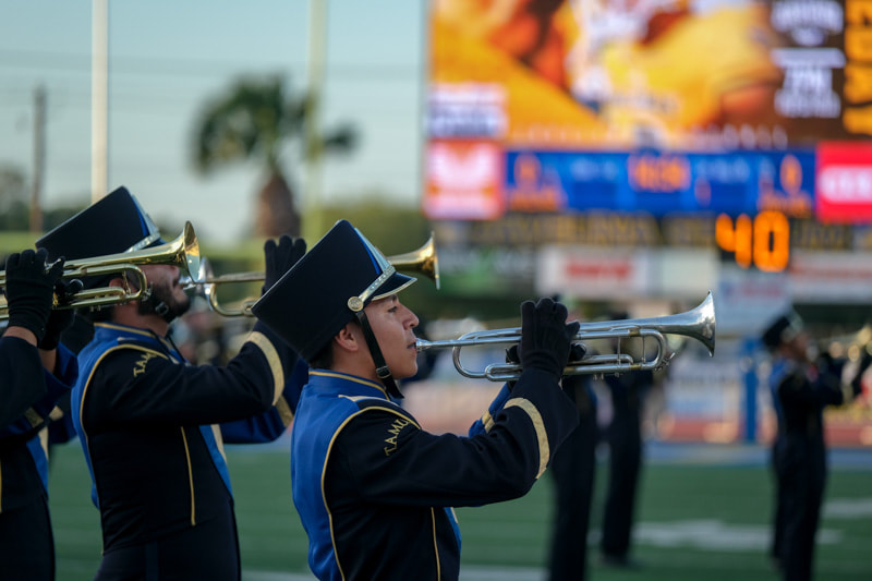 Javelina Marching Band trumpet players performing in blue, black, and gold uniforms