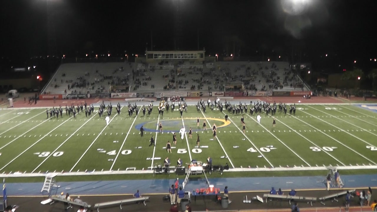 Javelina Marching Band spread across the football field during a nighttime homecoming performance